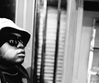 a black and white photo of a man in a hat and sunglasses