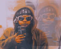 a person in a hoodie taking a selfie in a mirror